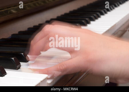 Nahaufnahme der Hand einer Frau, die Klavier spielen mit Bewegungsunschärfe Stockfoto