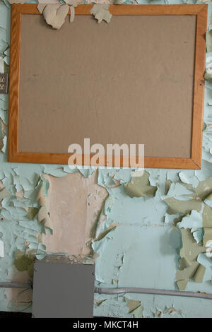 Holz gerahmt Kork Pinnwand Auf wand mit abgebrochenen und abblätternde Farbe mit kopieren. Stockfoto