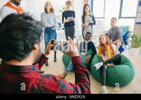 Nahaufnahme Rückansicht Schuß von jungen männlichen schießen die gemischten Rennen Teilnehmer der Ausbildung mit verschwommenen Hintergrund im Büro mit Panorama Fenster Stockfoto