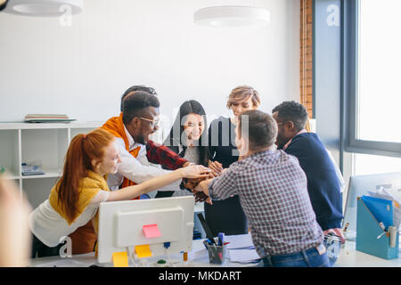 Internationalen Gruppe von Studenten, die Hände auf der Oberseite jeder andere. close-up-Bild Stockfoto