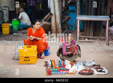 Auf einer Straße in Varanasi eine Mutter mit Blick auf ihre Tochter, als sie erfährt, wie Ihre Modeschmuck zu verkaufen. Stockfoto