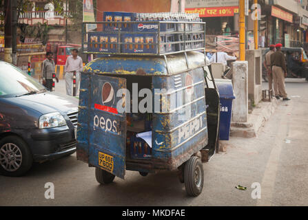 Die rosten, zerschlagene Lieferwagen Schnallen unter dem Gewicht aller Flaschen, die auf der Straße geliefert werden Stände in Varanasi. Stockfoto