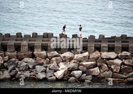 Jungen spielen auf Sea Wall Stockfoto