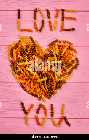 Ich liebe dich Text von Fusilli. Valentines Tag Hintergrund mit bunten Spirale Makkaroni. Happy Valentines Tag. Schöpferische liebe Beichte. Stockfoto