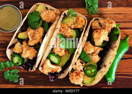 Roasted Coconut Blumenkohl Tacos. Gesunde, vegane Mahlzeit. Ansicht von oben auf einem hölzernen Hintergrund. Stockfoto