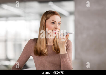 Frau mit Voice-Recorder auf Smartphone im Büro Stockfoto