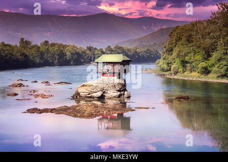 Drina Haus dramatischer Sonnenuntergang und Reflexion - Bunte kleine Haus auf dem Felsen in der Mitte der Drina in West Serbien Stockfoto