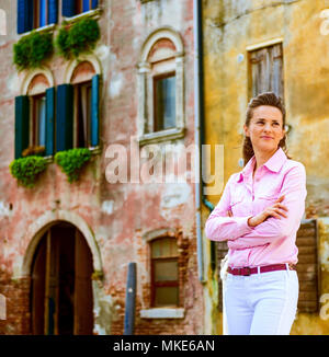 Entspannend, steht ein elegante weiblicher Touristen mit ihren Armen in der Nähe von Venedig-Kanal überquerte. Alles in Venedig ist so spannend... Stockfoto