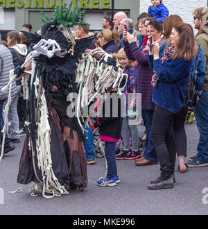 Farbenfroh gekleideten Street Performer Teil eines Jazz Festival Prozession als Hexe tanzen auf der Straße von ballydehob, Irland gekleidet Stockfoto