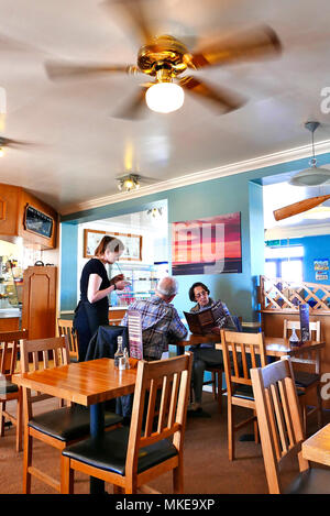 Junge Kellnerin mit einem Essen um von einem Paar mittleren Alters an einem Tisch im Café bei Knott Knott Ende Ende, Wyre, Lancashire, Großbritannien Stockfoto