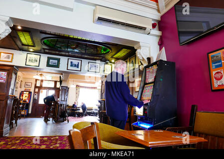 Mann spielt auf Gaming Maschine in Public House Stockfoto