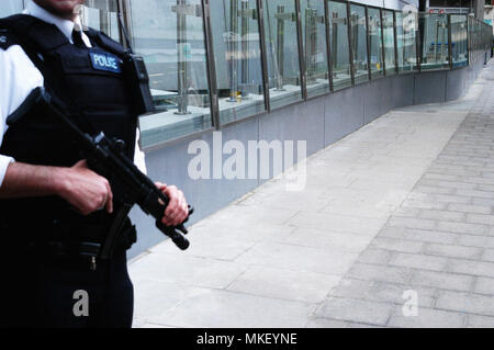 Metropolitan Police Protection Bewaffneter Polizeibeamter steht Wache vor New Scotland Yard Stockfoto