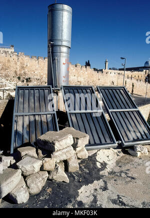 Drei Sonnenkollektoren von gerippten schwarzen Kunststoff hinter Glasscheiben absorbieren die Strahlen der Sonne eine einfache Heizung auf dem Dach mit heißem Wasser, um ein Haus in Jerusalem, der geteilten Stadt im Nahen Osten, der von Israel und Palästina beansprucht wird, zu erstellen. Solche kleine thermische Geräte wurden kommerziell in Israel in den 50er Jahren entwickelt, und heute ist die solare Wasser-Heizungen sind in fast 90 Prozent aller israelischen Haushalten zu finden. Stockfoto