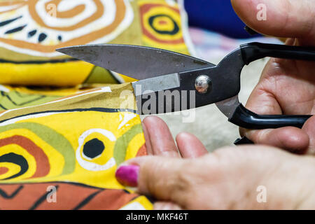 Nahaufnahme eines weiblichen Hand schneiden ein Stück Stoff mit einer Schere. Stockfoto