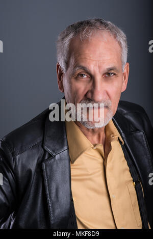 Portrait von älteren Mann mit leder jacke mit seinen Augen die Konzentration auf die Kamera Stockfoto