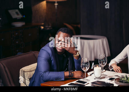Afrikanischer Mann Spaß haben, zu Tränen im Restaurant lachen Stockfoto