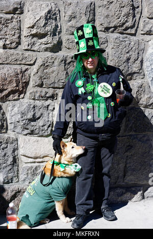 Ein Mann und sein Hund, beide trugen Grün für die Montreal St. Patrick's Day Parade Stockfoto