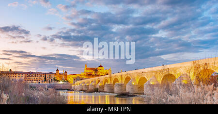 Beleuchtete Puente Romano, Römische Brücke über den Rio Guadalquivir, hinter Mezquita Catedral de Córdoba, Abendstimmung, Cordoba Stockfoto