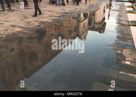 Stadt gebäude Reflexion in der großen Pfütze entlang der belebten Straße in Venedig, Italien Stockfoto