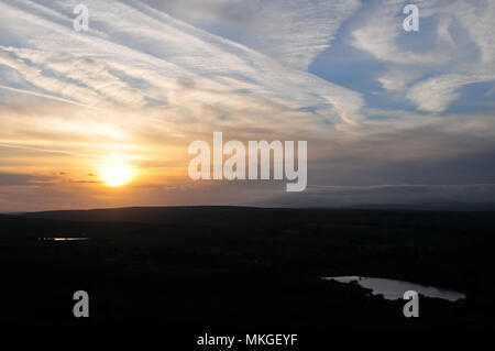 Weiße Sonne durch weiße Wolken Himmel versinken in grauer Horizont Wolken über Schwarzen Moor Hügel, westlich von Oxenhope, nördlich von Halifax, West Yorkshire, UK Stockfoto