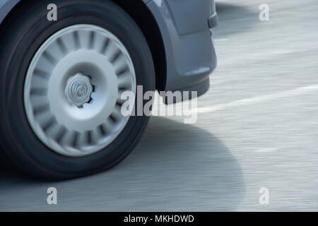 Dreht das Hinterrad des Autos fahren auf de straße. Moto abstrakt, Thema. Panning schoß, Bewegung, Bewegung, Dynamik. kalten, blauen Tönen. Platz für bearbeiten. Fahrzeug POV. Stockfoto