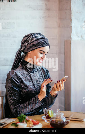 Muslimische Frauen Holding smartphonephone. Denken gute Erinnerungen. serfing social media Stockfoto