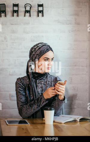 Moslemischen hijab Frauen Holding smartphonephone. Denken gute Erinnerungen. Stockfoto