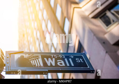 NEY YORK-USA - 28. Oktober 2017. Wall Street Schild im Vordergrund und eine riesige verschwommenes Gebäude im Hintergrund in Manhattan, New York, USA. Stockfoto