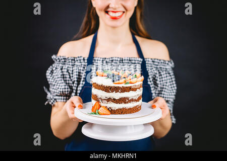 Fokus auf leckere Schokolade Kuchen mit cremiger Schichten, mit Beeren auf weißem serviertablett eingerichtet Stockfoto