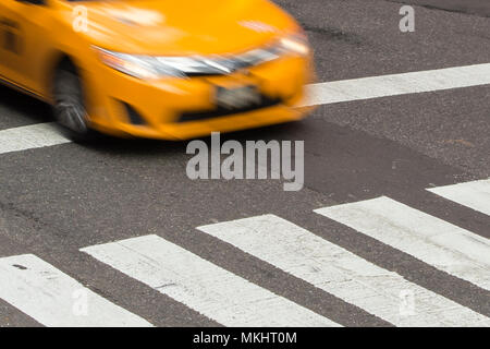 Gelbes Taxi in Bewegung auf der Fußgängerzone Streifen in Times Square, New York City, USA. Stockfoto