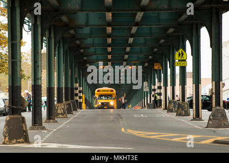 NEW YORK - USA - 1. November 2017. Ein Schulbus ist vorbei unter der Eisenbahnbrücke in der Bronx, New York City, USA. Stockfoto