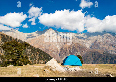 Ein einziger blauer Zelt gegen Dhaulahaar Gipfeln des Himalaya in Triund gesehen. Sonnigen Tag whit einige Wolken. Dharamshala, Himachal Pradesh. Indien Stockfoto