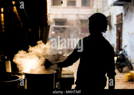 NEW DELHI - Indien - 11. Januar 2018. Silhouette eines indischen Mann Vorbereitung der berühmten Masala Chai. Ist ein aromatisierter Kaffee trinken von Brauerei Schwarz t Stockfoto