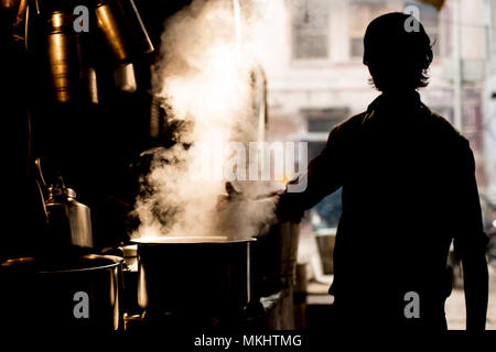 NEW DELHI - Indien - 11. Januar 2018. Silhouette eines indischen Mann Vorbereitung der berühmten Masala Chai. Ist ein aromatisierter Kaffee trinken von Brauerei Schwarz t Stockfoto