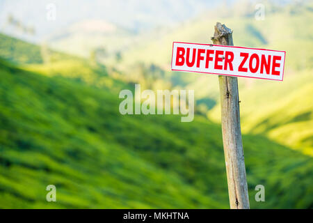 Ein Zeichen dafür, dass der sagt: "Pufferzone" liegt auf einem Hügel voller grüner Tee Plantagen in Munnar, Indien Stockfoto