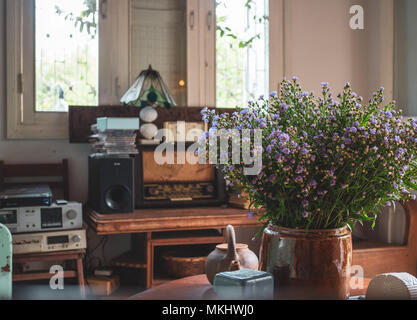 Wohnzimmer Dekoration mit Wildblumen, Keramik, Alte Lampe, Retro Radio Audio, Alte Viedo Player, Musik-CD und Holz- Fenster in traditionellen Vinta Stockfoto