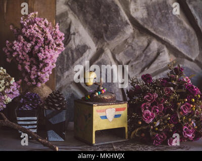 Alte Kaffeemühle, künstliche Blumen, Pinienzapfen, Vintage noch Leben auf Holz und Stein Wand Hintergrund Stockfoto