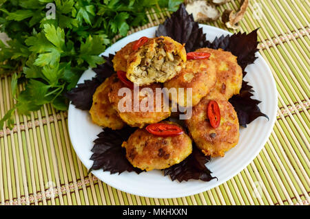 Saftige Burger aus Hackfleisch, gefüllte Champignons auf einem weißen Teller. Stockfoto