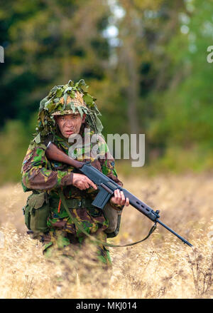 1970 - 1980 Soldat der britischen Armee in Tarnanzug und Stahlhelm mit einer SLR (Self-Loading Gewehr) L1A1-Kaliber von 7,62 mm (nach Modell gestellt) Stockfoto