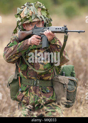 1970 - 1980 Soldat der britischen Armee in Tarnanzug und Stahlhelm mit einer SLR (Self-Loading Gewehr) L1A1-Kaliber von 7,62 mm (nach Modell gestellt) Stockfoto