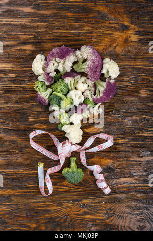 Ein Blumenkohl und Brokkoli mit einem Blumenstrauß auf einer hölzernen Hintergrund gefüttert Stockfoto