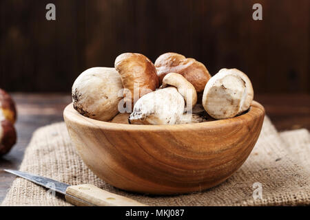 Pilze Steinpilze in eine hölzerne Schüssel über Holz- Hintergrund. Herbst Pilze Stockfoto