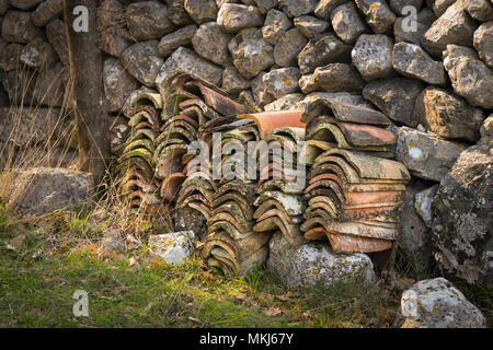 Ein Haufen von Dachpfannen liegen vor einer Mauer aus Stein in Kroatien (Insel Cres) Stockfoto
