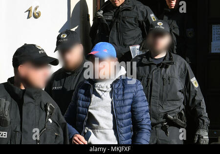 08 Mai 2018, Deutschland, Bremen: Polizisten festgenommen ein Mann aus einem Haus begleiten, ein Streifenwagen. Die deutsche Polizei hat eine groß angelegte Anti-menschenschmuggel Betrieb mit 800 Polizisten, die an Razzien in Wohnungen und Büros in Nord- und Mitteldeutschland. Der Grund für die Razzien wird die vermutete kommerzielle und Schleifring-basierten Handel mit Ausländern. Foto: Carmen Jaspersen/dpa - ACHTUNG: Individuelle(s) ist/sind verpixelt aus rechtlichen Gründen. Stockfoto