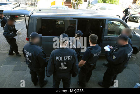 08 Mai 2018, Deutschland, Bremen: Polizisten um einen Streifenwagen, die Festgenommenen. Die deutsche Polizei hat eine groß angelegte Anti-menschenschmuggel Betrieb mit 800 Polizisten, die an Razzien in Wohnungen und Büros in Nord- und Mitteldeutschland. Der Grund für die Razzien wird die vermutete kommerzielle und Schleifring-basierten Handel mit Ausländern. Foto: Carmen Jaspersen/dpa - ACHTUNG: Individuelle(s) ist/sind verpixelt aus rechtlichen Gründen. Stockfoto