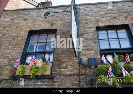 Windsor, Großbritannien. 8. Mai, 2018. Karton Ausschnitte von Prinz Harry und Meghan Markle Blick aus dem Fenster einer Kneipe in Vorbereitung für die königliche Hochzeit am 19. Mai. Credit: Mark Kerrison/Alamy leben Nachrichten Stockfoto