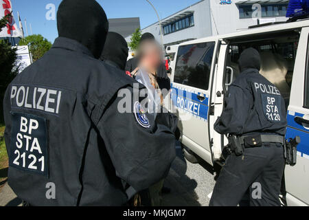 Bremen, Deutschland. 08 Mai 2018, Deutschland, Bremen: Deutsche Polizisten bringen eine verhaftet Verdächtigen zu einem Streifenwagen. Eine Bande ist der Menschenhandel Hunderte der Moldauer in Deutschland vermutet und sie illegal beschäftigt in Security Services. Foto: Bodo Marks/dpa - ACHTUNG: Individuelle(s) ist/sind verpixelt aus rechtlichen Gründen eine Gutschrift: dpa Picture alliance/Alamy leben Nachrichten Stockfoto