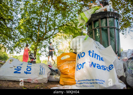 London, Großbritannien. 8. Mai, 2018. Mit einiger Ironie Supermarkt Plastiktüten Trompete "Ich bin zurück" (wie in Ich habe wiederverwendet worden) und 'keine Zeit für Abfall"-Müll von überquellenden Mülleimer entleert wird. Nach einem heißen Wochenende. Credit: Guy Bell/Alamy leben Nachrichten Stockfoto