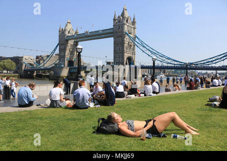 London, Großbritannien. 8. Mai. Eine Frau sunbathes in Potters Feld vor der Kulisse der berühmten Tower Bridge an einem warmen sonnigen Tag in der Hauptstadt der Credit: Amer ghazzal/Alamy leben Nachrichten Stockfoto