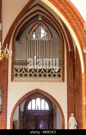 Innenraum eines Ziegelstein Kathedrale im gotischen Stil. Kleine metall Orgel und Eintritt in das Seitenschiff. St. Maria Magdalena Kirche. Wroclaw, Polen. Stockfoto